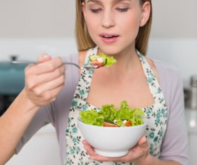 Housewife tasting salad Stock Photo