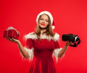 Lady holding christmas present and VR glasses Stock Photo