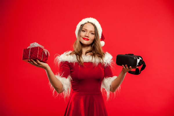 Lady holding christmas present and VR glasses Stock Photo