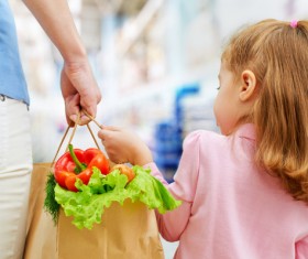 Little girl helping mother pick basket Stock Photo