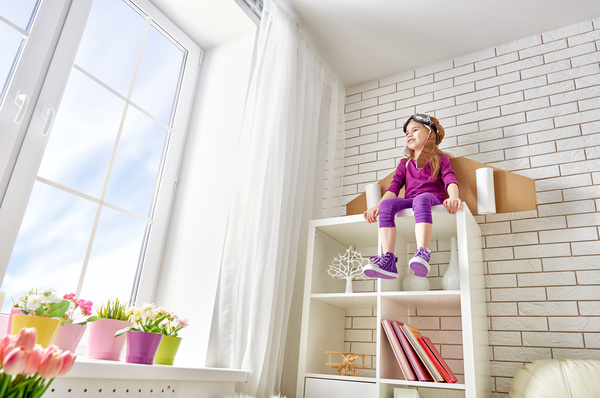 Little girl sitting on the wall cabinet Stock Photo