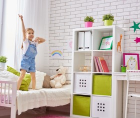Little girl standing in bed playing Stock Photo