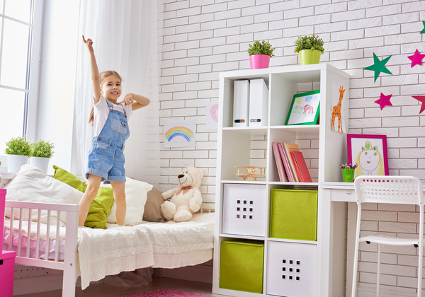 Little girl standing in bed playing Stock Photo