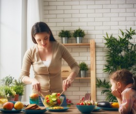 Little girl watching mother make salad Stock Photo