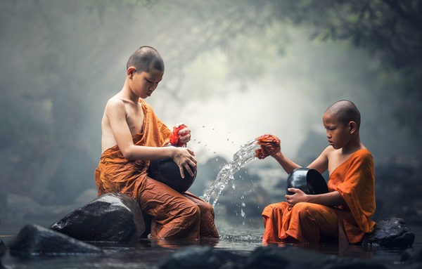 Little monk cleaning tableware in the stream Stock Photo 01