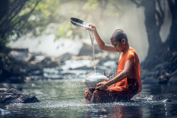 Little monk cleaning tableware in the stream Stock Photo 02