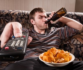 Man drinking beer watching TV Stock Photo
