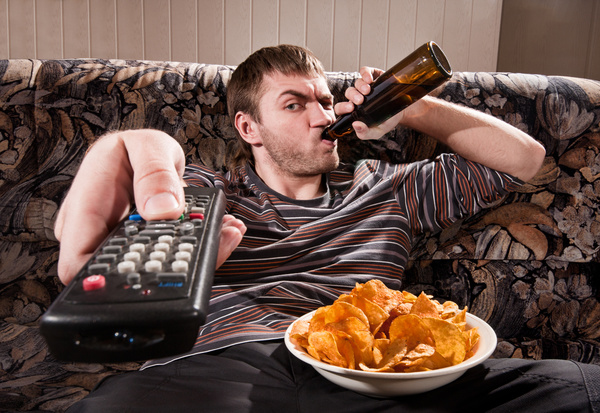 Man drinking beer watching TV Stock Photo