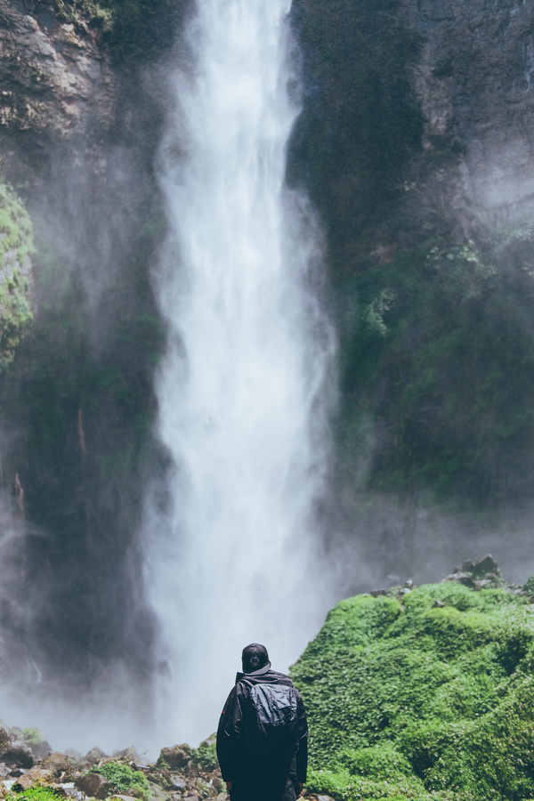 Man in front of beautiful waterfall Stock Photo