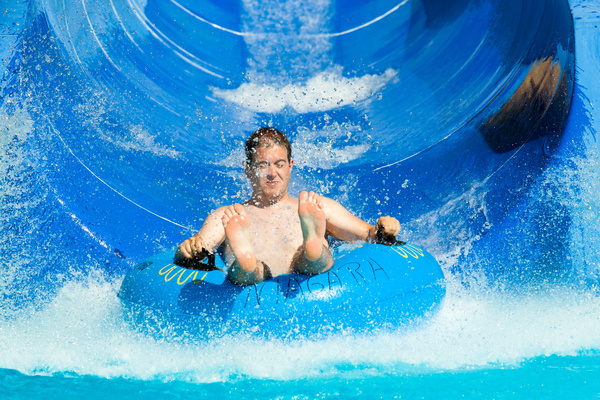 Man playing water slide Stock Photo