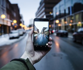 Man taking photo of cityscape with smartphone Stock Photo