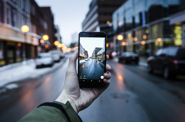 Man taking photo of cityscape with smartphone Stock Photo