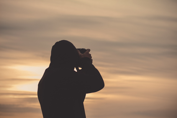 Man taking photo of sunset Stock Photo
