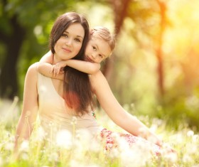 Mother and daughter sitting in the flowers Stock Photo