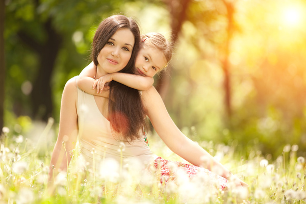 Mother and daughter sitting in the flowers Stock Photo