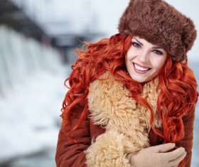Red-haired girl in fur coat outdoors in winter Stock Photo