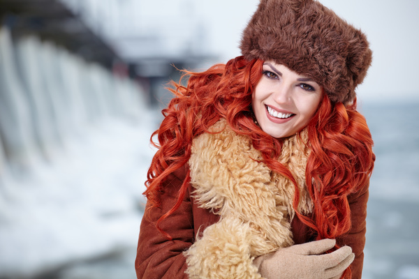 Red-haired girl in fur coat outdoors in winter Stock Photo