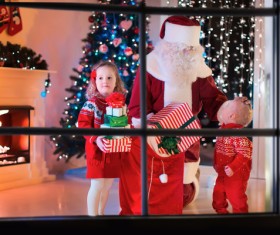 Santa Claus gives children presents Stock Photo