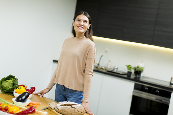 Smiling woman standing in the kitchen Stock Photo