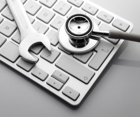 Stethoscope and wrench on the keyboard Stock Photo