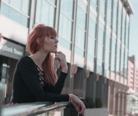 Stylish young girl relaxing outside modern building Stock Photo