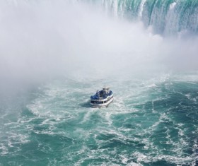 Vessel cruising on fierce waterfall Stock Photo