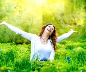 Woman sitting in the grass happy Stock Photo