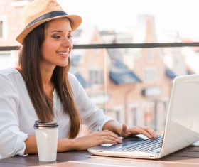 Woman using laptop at outdoor cafe Stock Photo 01