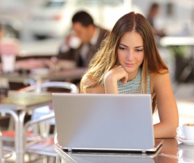 Woman using laptop at outdoor cafe Stock Photo 02