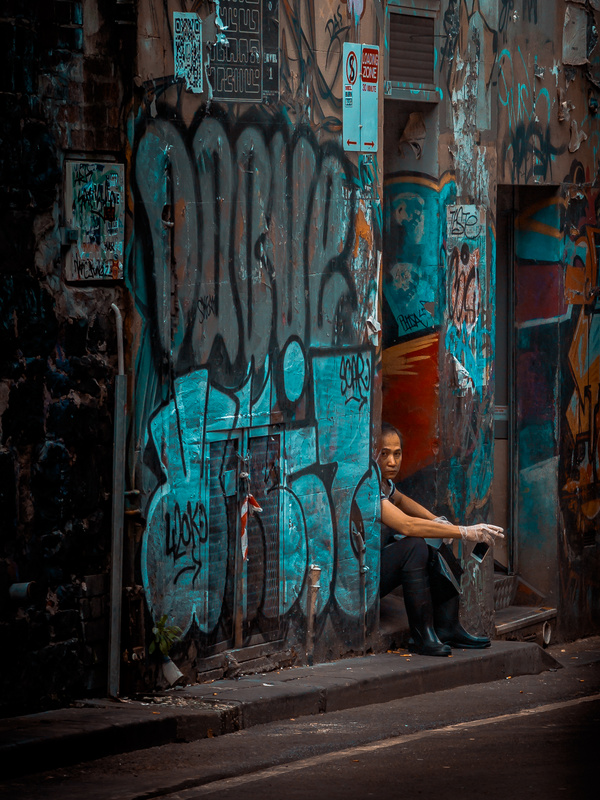 Young man resting near dirty painted wall Stock Photo
