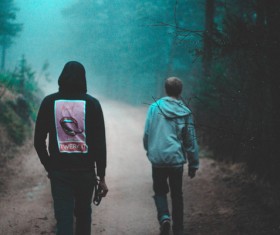 Young men walking on misty pathway Stock Photo