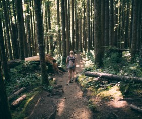 woman walking on pathway in forest Stock Photo