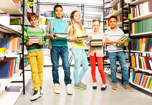 Children holding books in the library Stock Photo