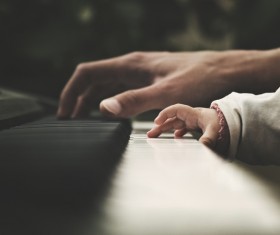 Closeup father and baby playing piano Stock Photo