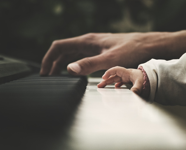 Closeup father and baby playing piano Stock Photo
