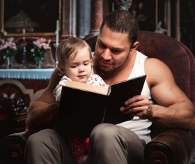 Dad reading book with her daughter Stock Photo