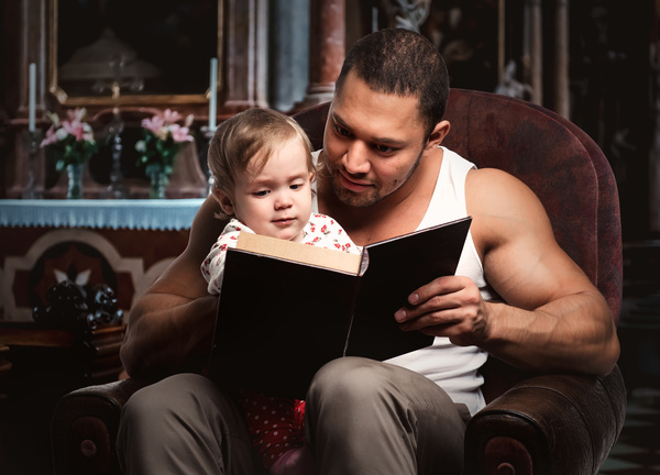 Dad reading book with her daughter Stock Photo