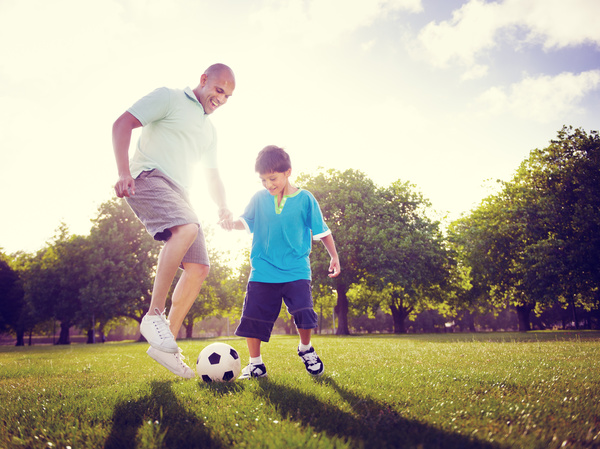 Father and son playing football Stock Photo