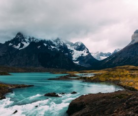 Flowing river and snow-covered mountains Stock Photo