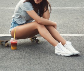 Girl sitting on skateboard Stock Photo 02