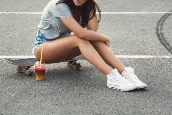 Girl sitting on skateboard Stock Photo 02