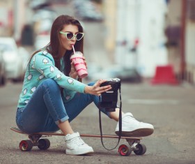 Girl sitting on skateboard selfie Stock Photo