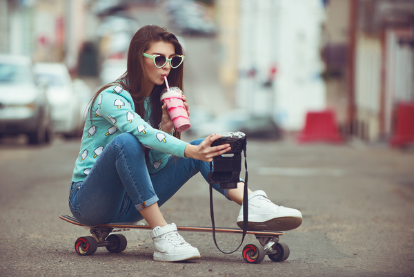 Girl sitting on skateboard selfie Stock Photo