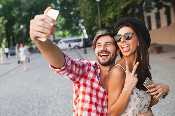 Lovers using smart phone selfie funny face Stock Photo