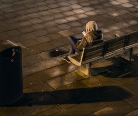 Man sitting on bench playing cellphone Stock Photo