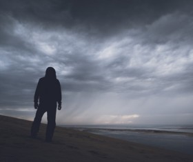 Man standing alone on beach Stock Photo