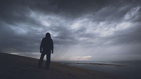 Man standing alone on beach Stock Photo