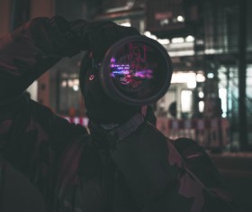 Man taking photograph with modern camera at night Stock Photo
