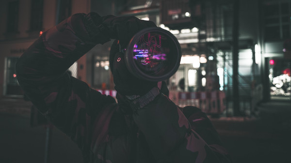 Man taking photograph with modern camera at night Stock Photo