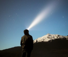 Man watching starry sky with head lights Stock Photo